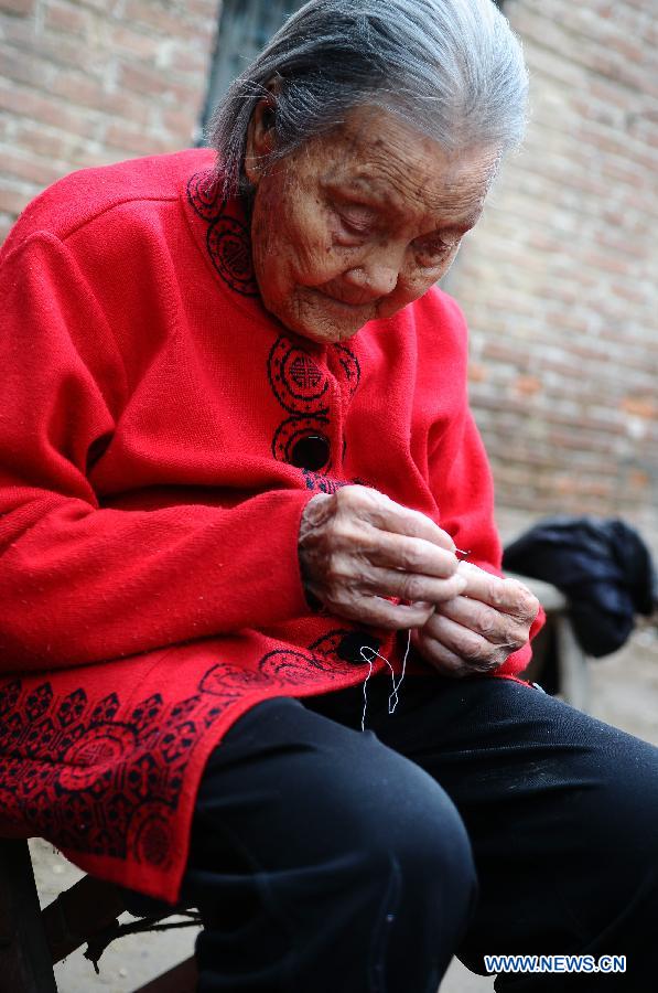 Wang Jingzhi shows her sewing work during her 113th birthday party in Yanggu County of Liaocheng City, east China's Shandong Province, May 27, 2013. Wang, an elder living at Wangzhuang Village of Yanggu County, celebrated her 113th birthday on Tuesday. Having four daughters and more than 110 offsprings, Wang has become the oldest in Liaocheng City. (Xinhua/Zhang Zhenxiang)