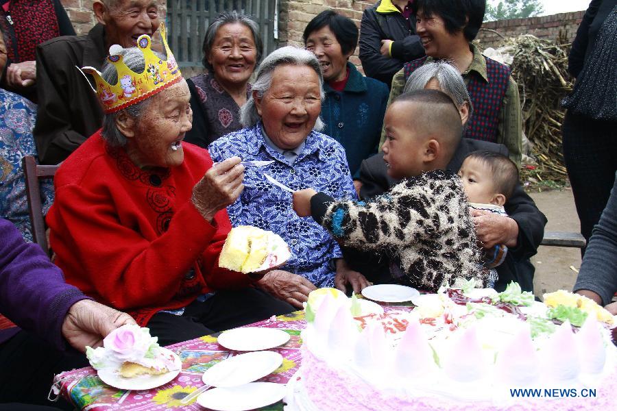 Wang Jingzhi (L) plays with her great-great-grandsons during her 113th birthday party in Yanggu County of Liaocheng City, east China's Shandong Province, May 27, 2013. Wang, an elder living at Wangzhuang Village of Yanggu County, celebrated her 113th birthday on Tuesday. Having four daughters and more than 110 offsprings, Wang has become the oldest in Liaocheng City. (Xinhua/Zhang Zhenxiang)