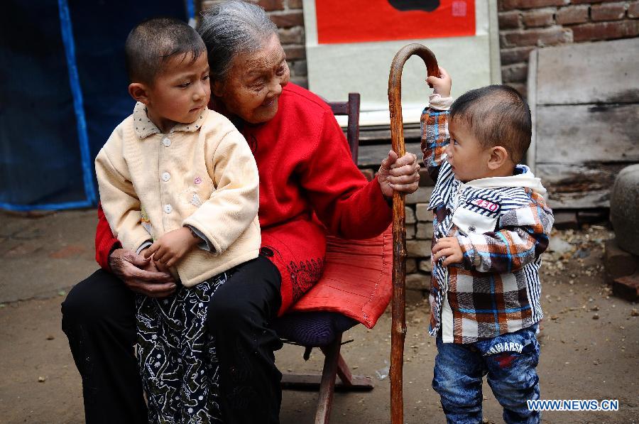 Wang Jingzhi (C) plays with two of her great-great-grandsons during her 113th birthday party in Yanggu County of Liaocheng City, east China's Shandong Province, May 27, 2013. Wang, an elder living at Wangzhuang Village of Yanggu County, celebrated her 113th birthday on Tuesday. Having four daughters and more than 110 offsprings, Wang has become the oldest in Liaocheng City. (Xinhua/Zhang Zhenxiang)