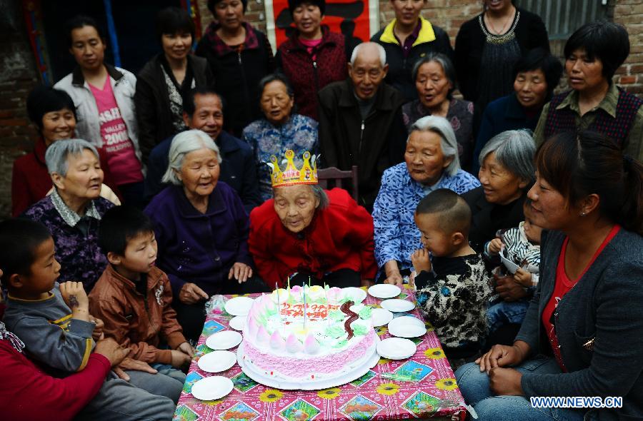 Wang Jingzhi (C) blows birthday candles during her 113th birthday party in Yanggu County of Liaocheng City, east China's Shandong Province, May 27, 2013. Wang, an elder living at Wangzhuang Village of Yanggu County, celebrated her 113th birthday on Tuesday. Having four daughters and more than 110 offsprings, Wang has become the oldest in Liaocheng City. (Xinhua/Zhang Zhenxiang)