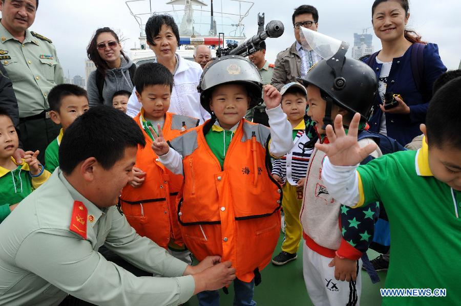 Children visit a patrol boat during an open day of local frontier defense vessel division in Qingdao, a coastal city in east China's Shandong Province, May 28, 2013. (Xinhua/Li Ziheng)