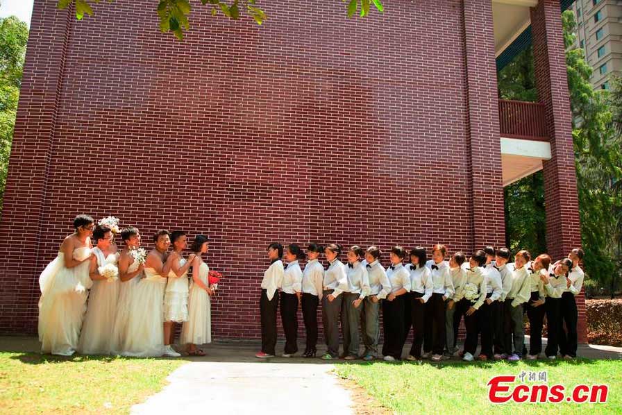 Boys wearing wedding dresses and girls in men's suits pose for graduation group photos at Hunan University of Arts and Science in Changde, central China's Hunan Province. [Photo: CNS/Jia Siyuan] 