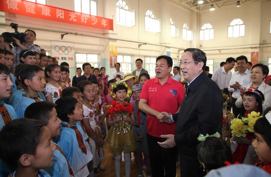 Photo taken on May 24, 2013 shows Yu Zhengsheng (front, R), a member of the Standing Committee of the Political Bureau of the Communist Party of China (CPC) Central Committee and chairman of the National Committee of the Chinese People's Political Consultative Conference, sings with students and faculty members in No. 18 Primary School of Kashgar City, northwest China's Xinjiang Uygur Autonomous Region. Yu paid an inspection tour in Hotan, Kashgar, Yili and Urumqi of Xinjiang from May 23 to 28. (Xinhua/Liu Weibing)