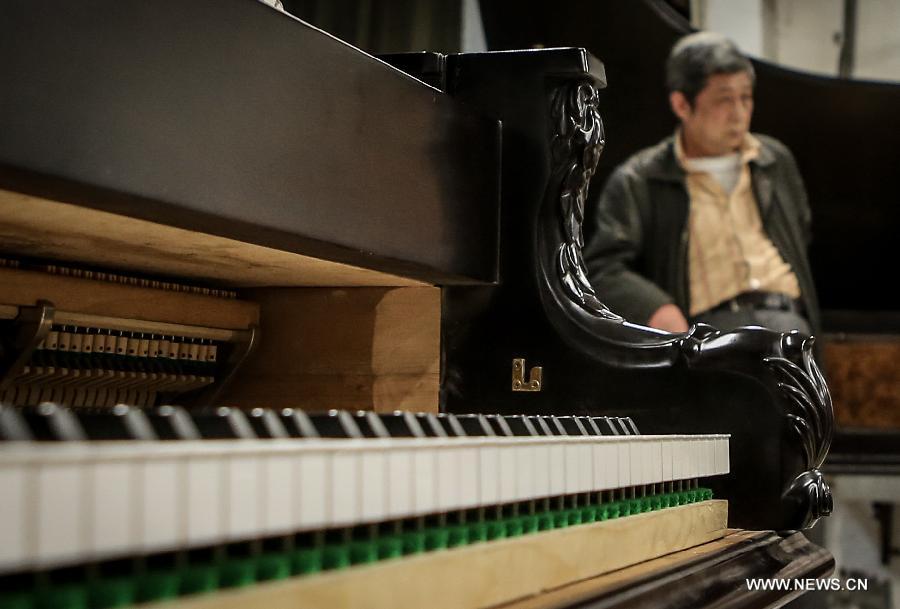 Photo taken on May 17, 2013 shows Zhang Gangning, a piano maker, rests at his piano room in Nanjing, capital of east China's Jiangsu Province.  (Xinhua/Yang Lei)