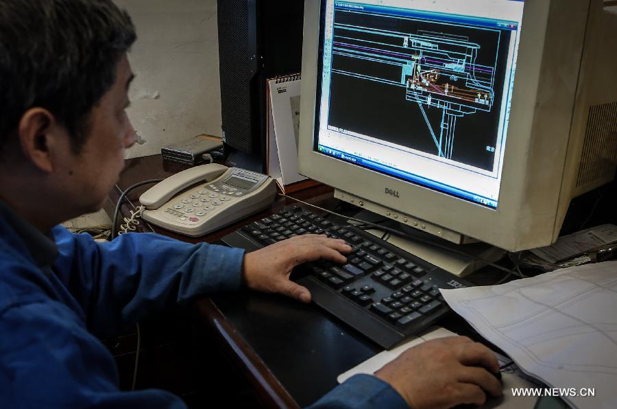 Photo taken on May 8, 2013 shows Zhang Gangning, a piano maker, works on his design drawing of his piano at his house in Nanjing, capital of east China's Jiangsu Province. Zhang's interest in piano-making started 13 years ago.  (Xinhua/Yang Lei)