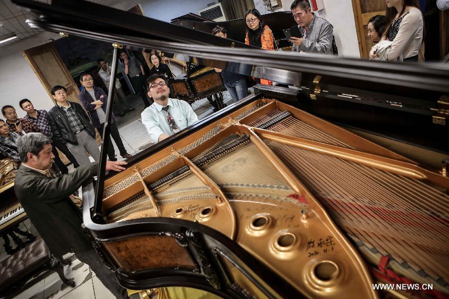 Photo taken on May 17, 2013 shows Zhang Gangning (L front), a piano maker, gathers with his friends at his house in Nanjing, capital of east China's Jiangsu Province. Zhang's interest in piano-making started 13 years ago.  (Xinhua/Yang Lei)