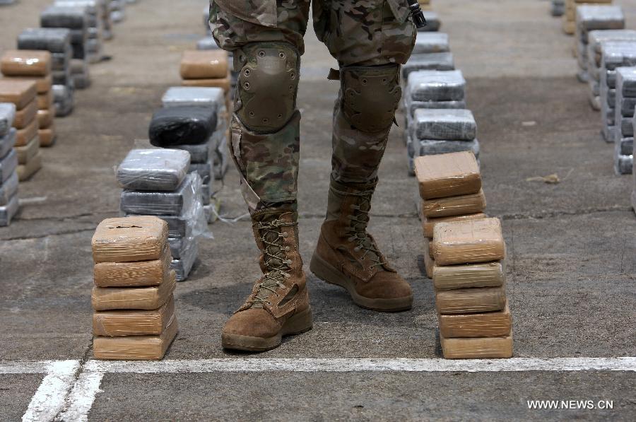 A member of the Aeronaval National Service guards cocaine packs siezed in the "Santisima Trinidad" operation, in the Guna Yala shire, during a presentation to media, in Panama City, capital of Panama, on May 27, 2013. According to official sources, the 2,717 kilograms of cocaine and two kilograms of marijuana are the biggest drug seizure by now in 2013, accomplished with United States support. The Aeronaval National Service has seized over 10,000 kilograms of illegal substances so far this year. (Xinhua/Mauricio Valenzuela) 