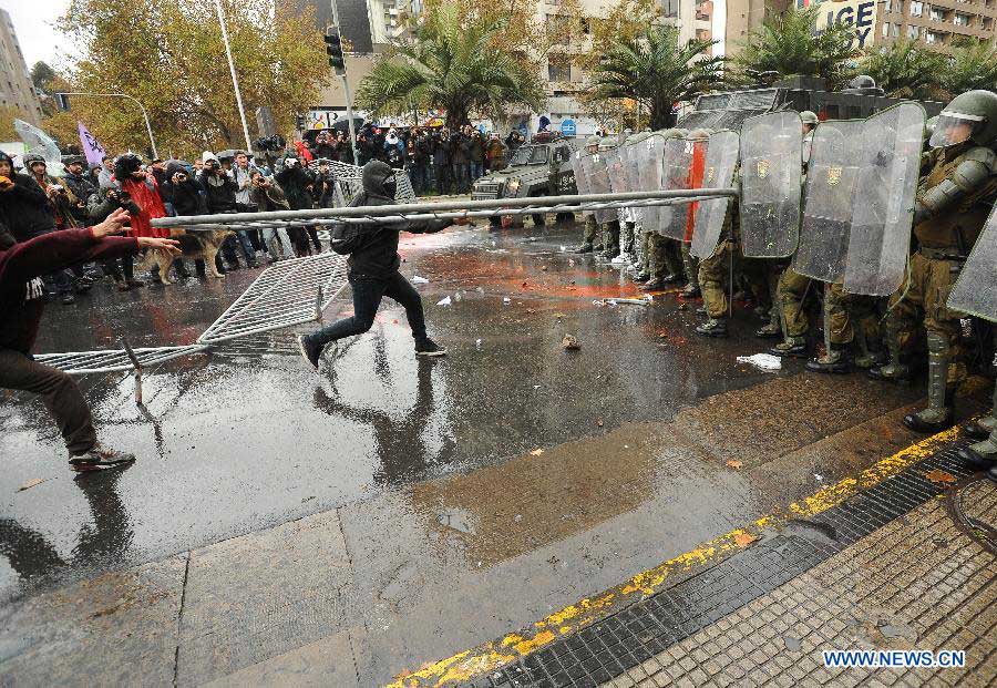 Students clash with riot police during a protest called by the Chilean Coordinating Assembly of High School Students (ACES), the Chilean National Coordination of Students of High School (Cones), the Council of Student Federations of Chile (CONFECH) and the Movement of Students of Private Higher Education (MESUP), in Santiago, capital of Chile, on May 28, 2013. The students demanded a dignified and free education without lucre, according to local media. (Xinhua/Jorge Villegas) 