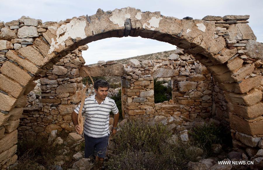 Yiannis Gavalas, a principal of the only school in Iraklia island, explores on a hill in Iraklia island, Greece, on May 23, 2013. For over 20 years, Gavalas has been working in this tiny island covers an area of 18 square kilometers with more than 100 residents. He has recorded about 650 species of plants, 174 species of birds and 26 species of butterflies in his spare time. He has published a book about local butterflies and more will follow. (Xinhua/Liu Yongqiu)