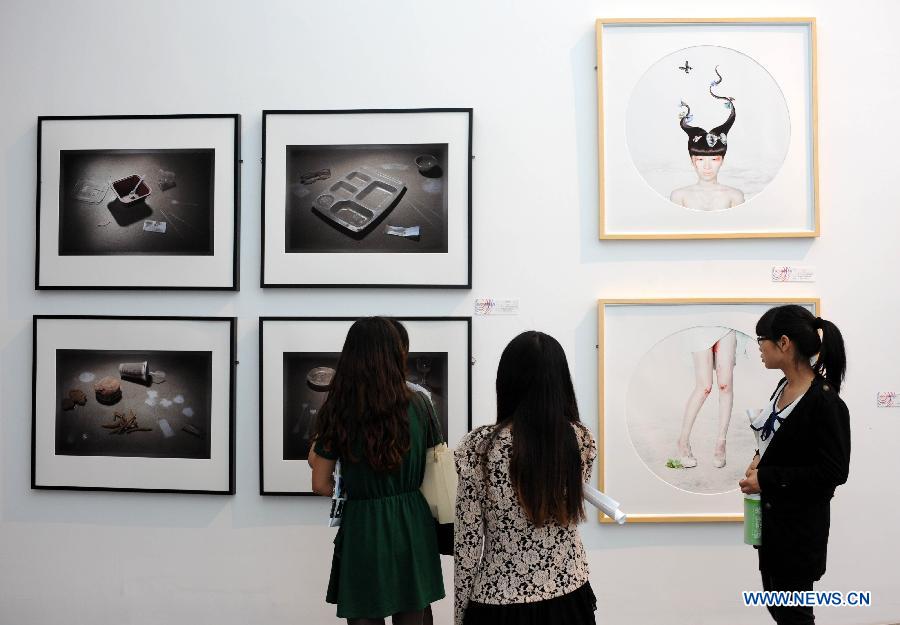 Visitors watch photography works produced by graduates from Nanjing University of the Arts in Nanjing, capital of east China's Jiangsu Province, May 28, 2013. (Xinhua/Sun Can)  