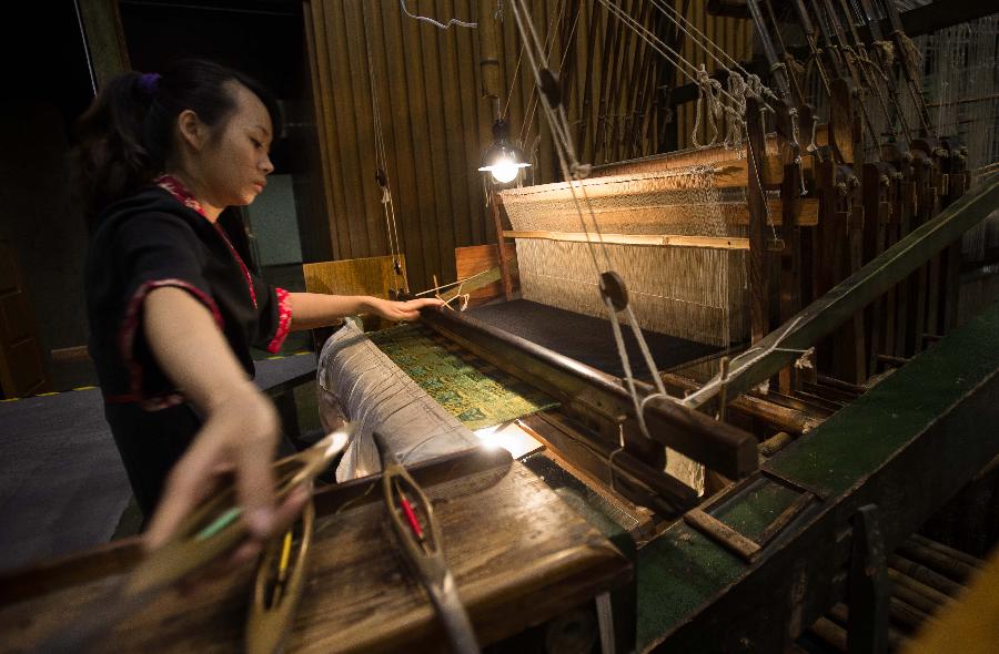 A weaver weaves Shu brocade, a traditional artwork in southwest China's Sichuan Province, with a loom, in Chengdu, capital of Sichuan, May 27, 2013. Imparted from generation to generation for over 2,000 years, Shu brocade weaving techniques have been put on China's Intangible Cultural Heritage List in 2006. (Xinhua/Li Qiaoqiao) 