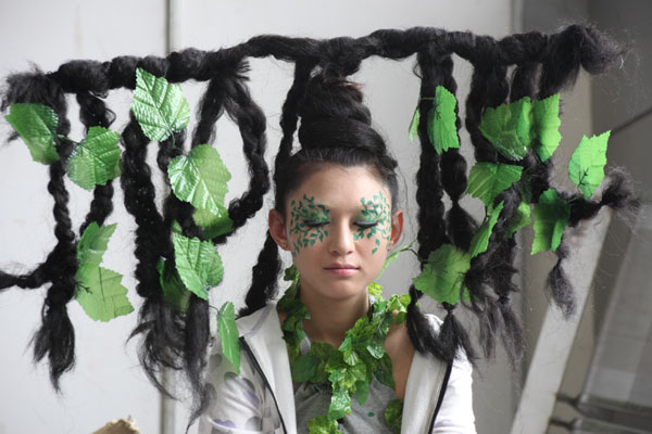 A Shandong University of Art and Design senior dresses up with headwear at a design art show in Jinan on Tuesday. The art show was held by senior students of the university who will graduate this summer. (China Daily / Zheng Tao)