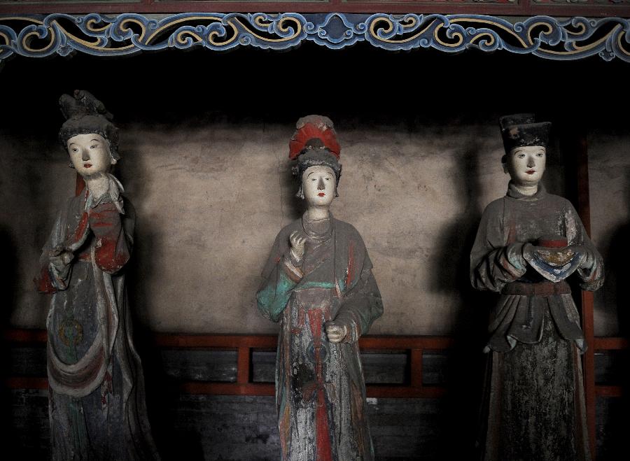 Photo taken on May 24, 2013 shows colored sculptures at the Shengmu Dian (Hall of the Saint Mother) of Jinci Temple in Taiyuan, capital of north China's Shanxi Province. Jinci Temple was first built during the period of the Northern Wei (386-534) in commemoration of Shuyu, the second son of Emperor Wuwang of the Zhou dynasty (1100-771 BC). Shengmu Dian is the principal hall in the temple, built to honor the mother of Shuyu, featuring 42 various sculptures of maids. (Xinhua/Yan Yan) 