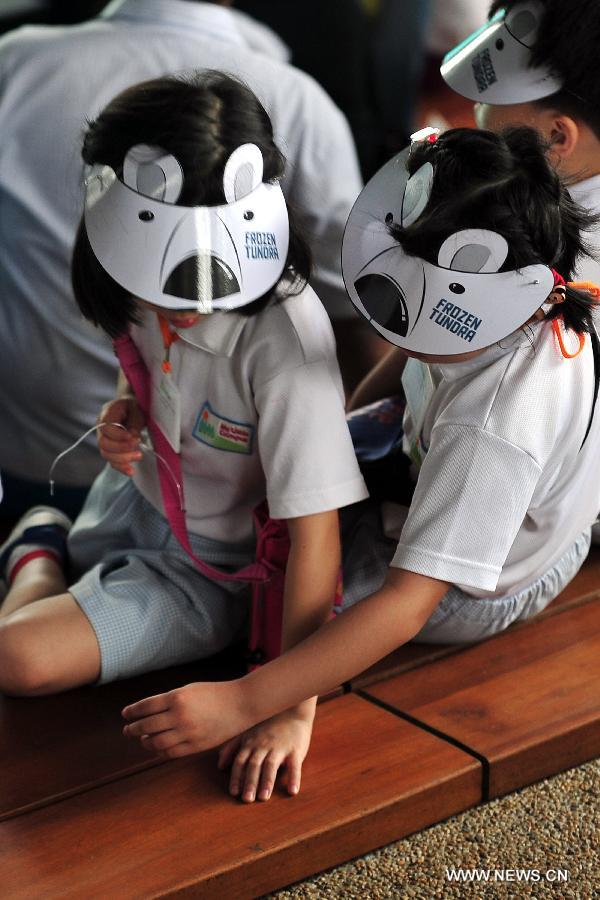 Children sit on the chair at the Singapore Zoo, May 29, 2013. The Singapore Zoo celebrated the moving of Inuka, the first polar bear born in the Singapore Zoo and the tropics, into its new enclosure by hosting a housewarming ceremony on Wednesday. (Xinhua/Then Chih Wey) 