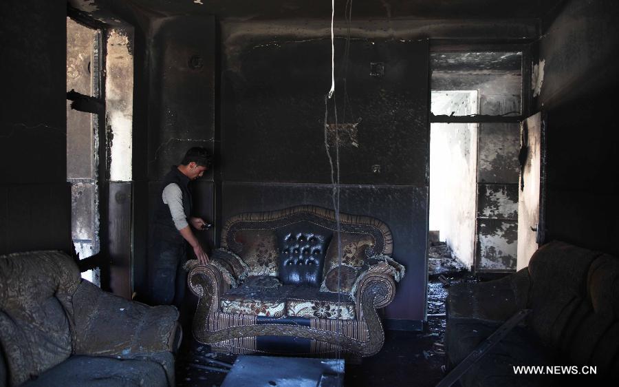 An Afghan policeman works at the suicide attack site on Panjshir governor compound in Panjshir province, Afghanistan, on May 29, 2013. One policeman and six militants were killed early Wednesday morning when Taliban suicide bombers launched an attack on the provincial governor office building in eastern Afghan province of Panjshir, a provincial source said. (Xinhua/Ahmad Massoud) 