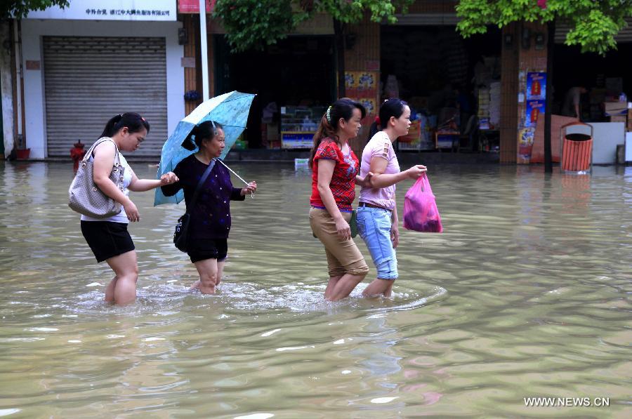 People hold each other's hands when walking on the flooded road in Fengshan County, south China's Guangxi Zhuang Autonomous Region, May 29, 2013. Fengshan County was hit by the heaviest rainfall of the year on Wednesday morning. (Xinhua/Zhou Enge) 