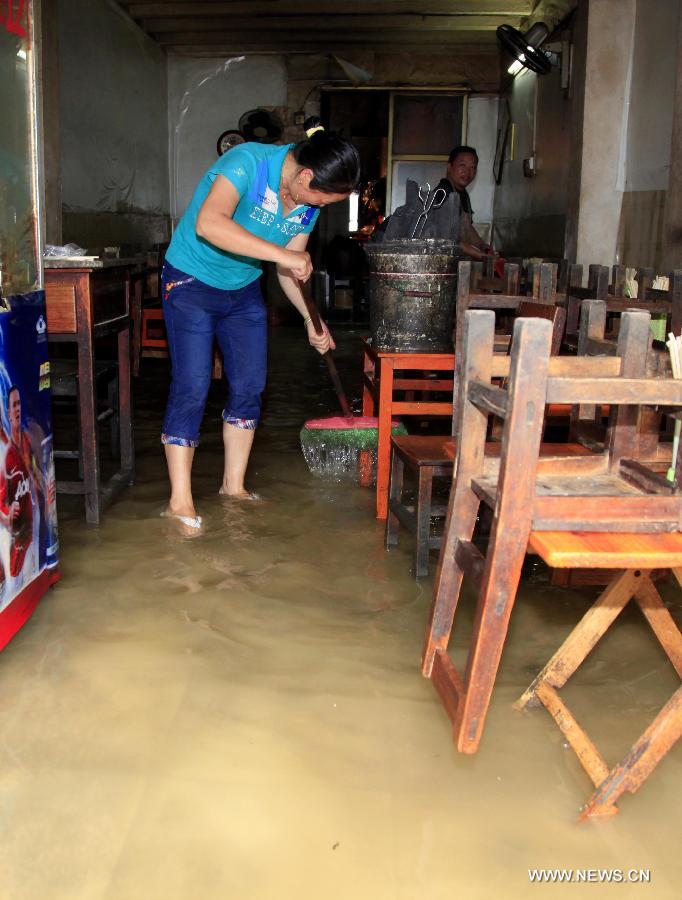 A woman cleans her flooded shop in Fengshan County, south China's Guangxi Zhuang Autonomous Region, May 29, 2013. Fengshan County was hit by the heaviest rainfall of the year on Wednesday morning. (Xinhua/Zhou Enge) 