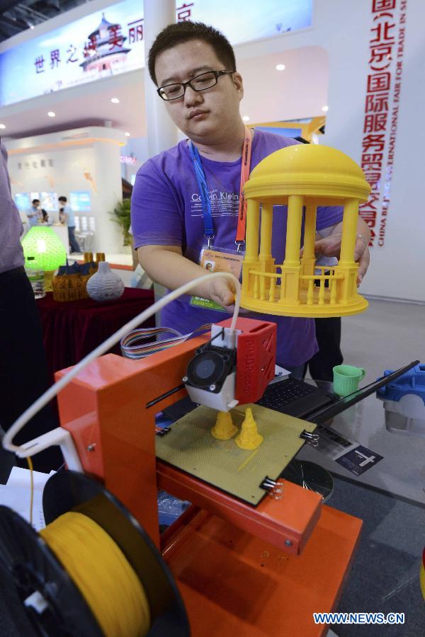 An exhibitor displays a 3D printer model at China Beijing International Fair for Trade in Services (Beijing Fair) in Beijing, capital of China, May 29, 2013. (Xinhua/Zheng Yong)