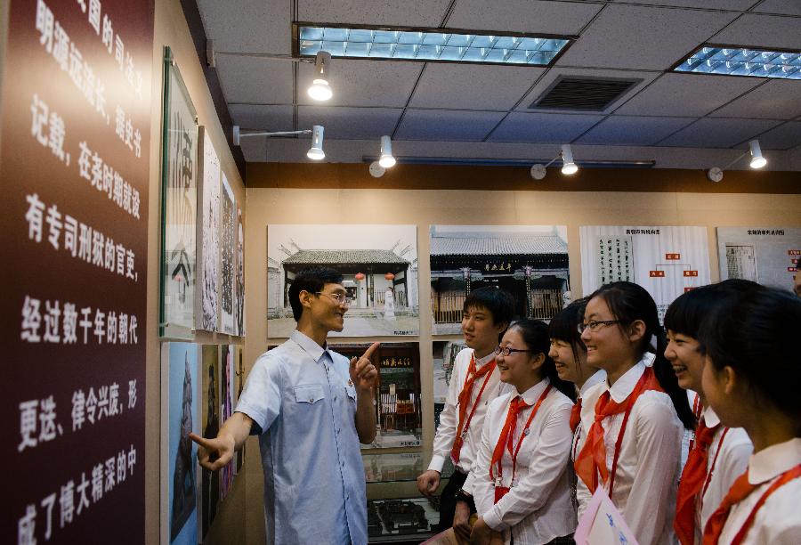 Wang Haibo (L), curator of China Courts Museum, introduces China's judicial system to students who come to visit the Supreme People's Court on the court's open day in Beijing, capital of China, May 30, 2013. More than 120 students and teachers from Banchang Elementary School and No. 166 Middle School visited the Supreme People's Court on its open day on May 30. (Xinhua/Wang Quanchao)