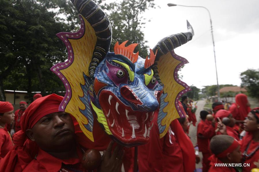 Dancers called "Diablos" of Yare, visit town's shrines on the frame work of Corpus Christi celebrations, at San Francisco de Yare population, in Miranda State, Venezuela, on May 29, 2013. The dancing diablos of Yare pay promises dancing with devil suits, making sound with percussions, along Yare streets. On December 6, 2012, these dancers were declared Humanity's Cultural Intangible Heritage by United Nations for Education, Science and Culture Organization (UNESCO). (Xinhua/Juan Carlos Hernandez)