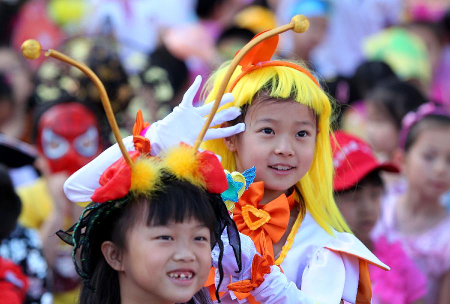 Pupils of Zhongguancun No. 1 Primary School watch performances during an art festival held by the school for celebrating the International Children's Day in Beijing, capital of China, May 30, 2013. (Xinhua/Wang Ying) 