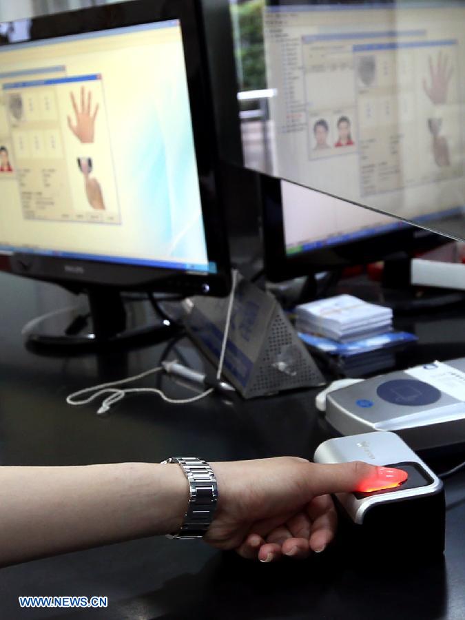 A citizen registers her fingerprint information at a police station in Shanghai, east China, May 30, 2013. The Shanghai police announced on Thursday that the city will start collecting fingerprint information of its citizens for ID card recognition across the region as of July 1, which can help better protect the legal rights of the citizens and also safeguard state safety and social stability. The city has by far started the program in 233 police stations and has registered the fingerprint information of 10,756 citizens. (Xinhua/Fan Jun)  