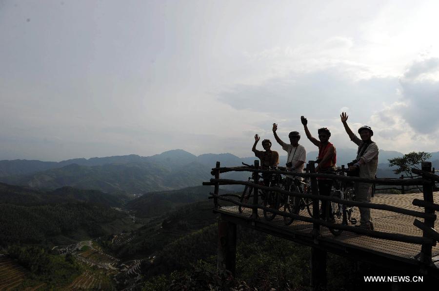 Tourists ride bicycles to visit the terraces in Chongyi County, east China's Jiangxi Province, May 29, 2013. Chongyi County, located in southwest Jiangxi Province, is well-known for its high forest coverage rate, which reaches 88.3 percent, and its slower pace of life. (Xinhua/Tang Yanlan)