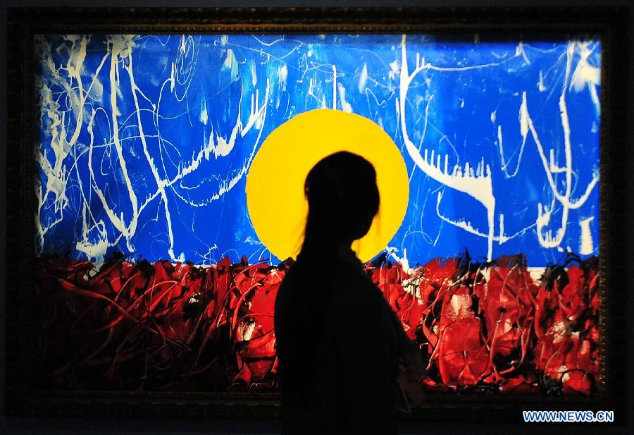 A visitor looks at a painting of Antonio Meneghetti, the father of onto-psychology, at an exhibition in Wuhan, capital of central China's Hubei Province, May 30, 2013. An exhibition of Meneghetti's paintings kicked off at the provincial museum here on Thursday. Meneghetti, who was supposed to attend his exhibition's opening ceremony, has passed away on May 20 at the age of 77 in Italy. (Xinhua/Xiao Yijiu)