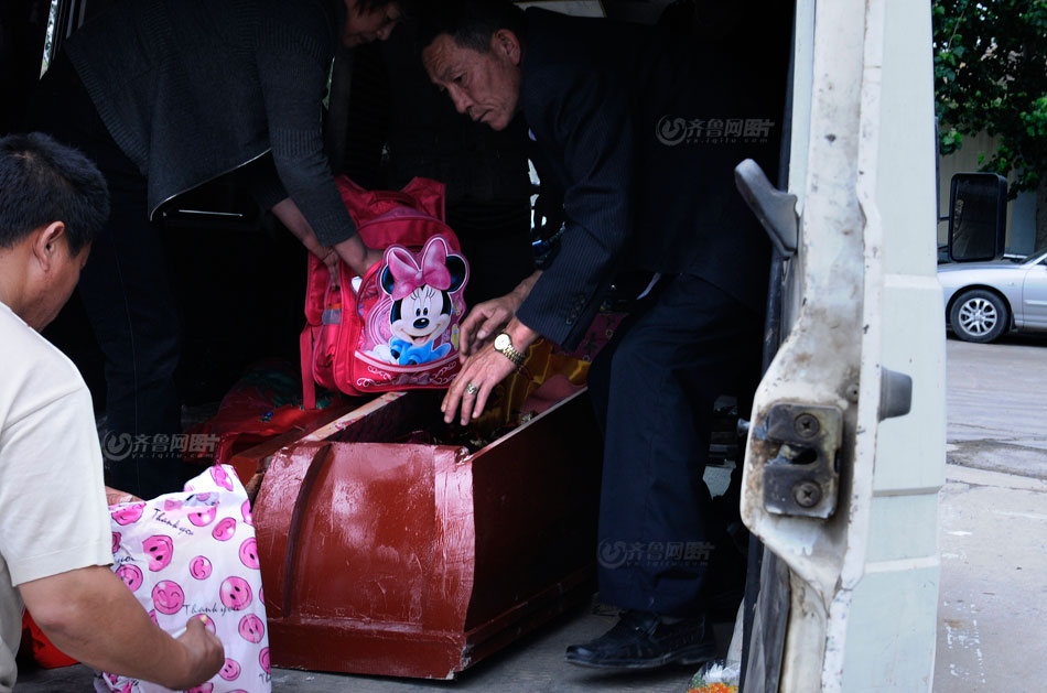 Xu's father prepares new dress and school bag to go with her before the funeral. (www.iqilu.com/ Yu Peng)