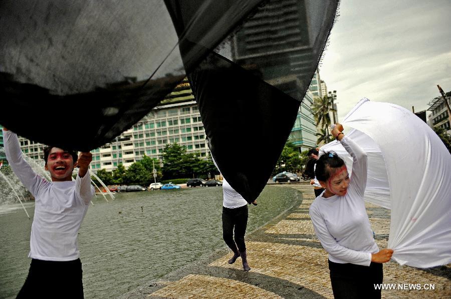 Performers from Komunitas Kretek, or the Cigarette Community, spread white and black clothes in their performance on the World No Tobacco Day in Jakarta, Indonesia, May 31, 2013. Indonesian cigarette community refused commemoration of the World No Tobacco Day on May 31. About 70 percent of adult males smoke in Indonesia. (Xinhua/Agung Kuncahya B.) 