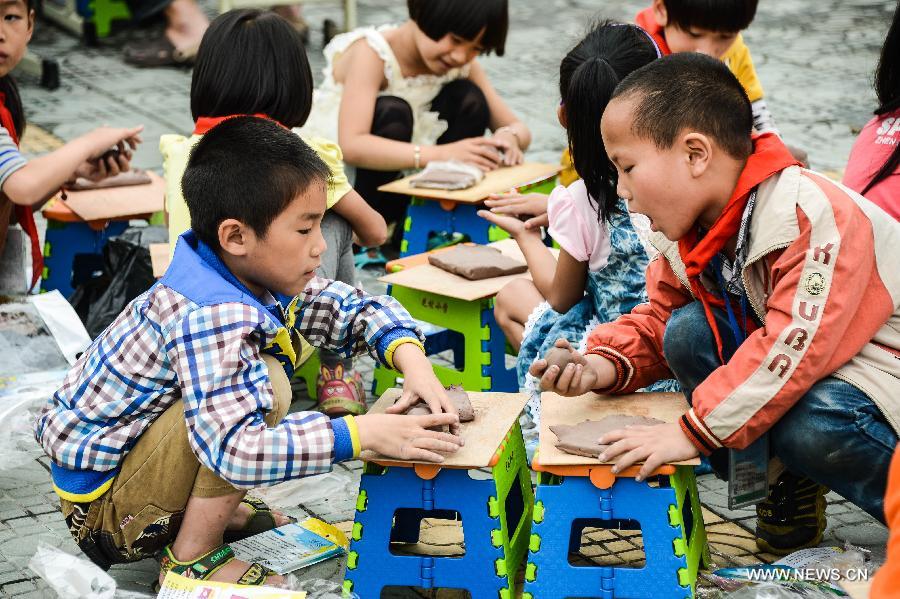 Students of Zhicun Central Elementary School make clay sculptures during the school's Mud Culture Festival in Chongfu Township of Tongxiang City, east China's Zhejiang Province, May 31, 2013. (Xinhua/Xu Yu)