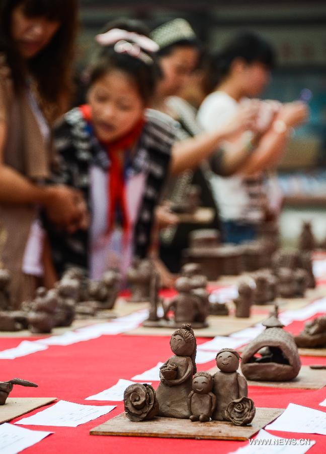 Students of Zhicun Central Elementary School make clay sculptures during the school's Mud Culture Festival in Chongfu Township of Tongxiang City, east China's Zhejiang Province, May 31, 2013. (Xinhua/Xu Yu)