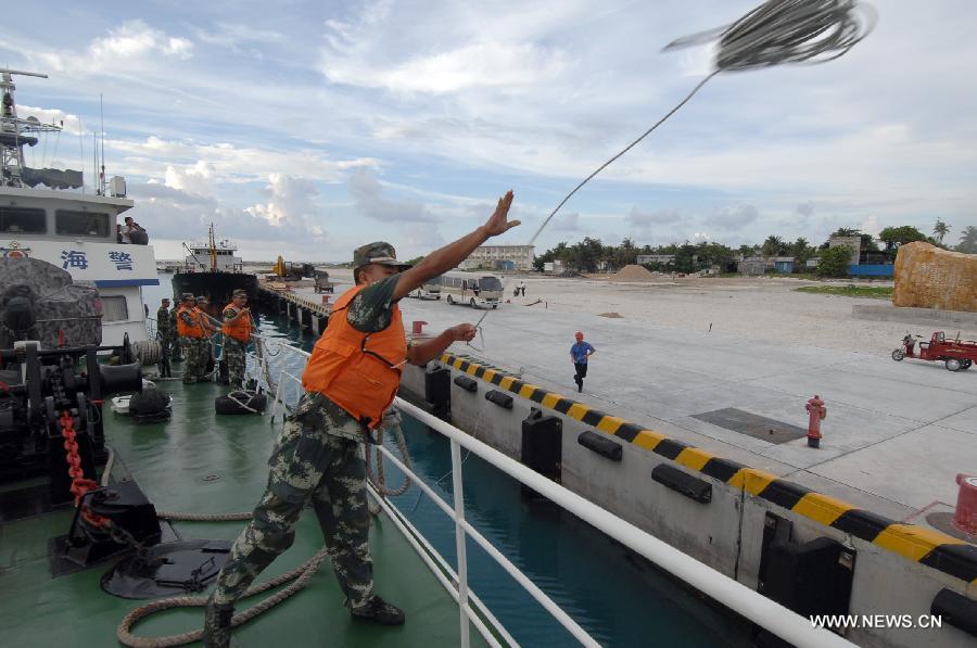 A marine officer throws out a rope after the China Coast Guard vessel 46001 arrives at the Yongxing Island of Sansha City, south China's Hainan Province, May 31, 2013. The vessel accomplished a 10-hour patrol of the sea areas around Yongle Islands on Friday. (Xinhua/Wei Hua)