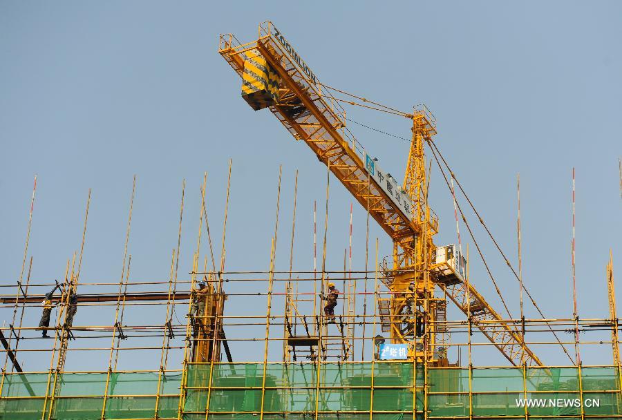 Photo taken on May 21, 2013 shows workers work on a buidling under construction in the high-tech zone of Chengdu, capital of southwest China's Sichuan Province. By the end of 2012, Chengdu's GDP has reached 800 billion RMB (about 130.48 billion U.S. dollars), ranking the 3rd place in China's sub-provincial cities. By May of 2013, more than 230 enterprises in the Fortune 500 have come to Chengdu. The 2013 Fortune Global Forum will be held in Chengdu from June 6 to June 8. Chengdu, an ancient city with a history of over 2,300 year, is developing into an international metropolis with its huge economic development potential as well as its special cultural environment. (Xinhua/Shen Hong)