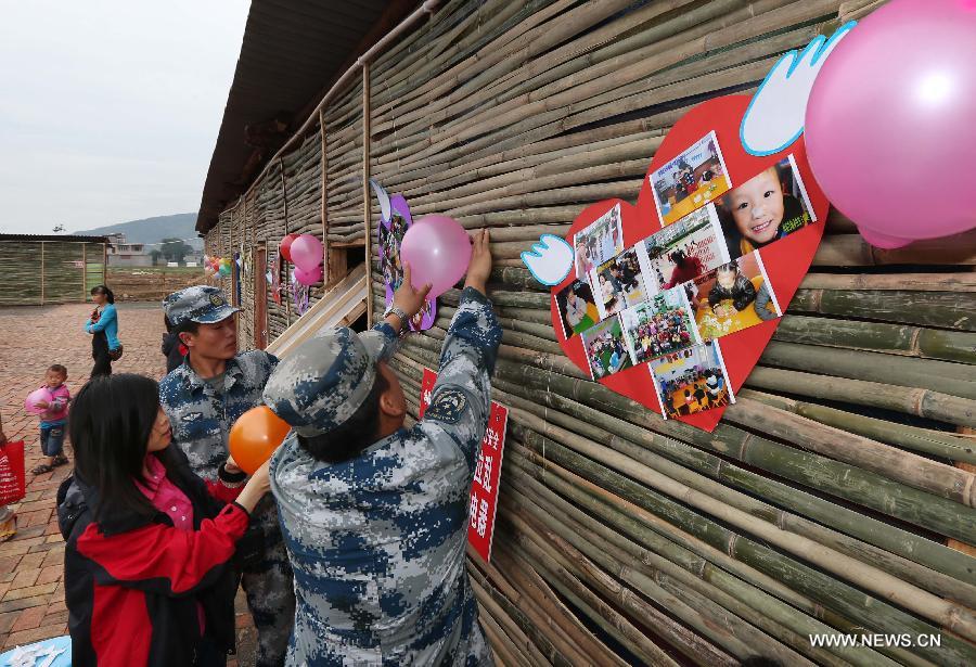 Soldiers set up a children's park in makeshift houses in Longmen Township of Lushan County in Ya'an City, southwest China's Sichuan Province, June 1, 2013. Children in Lushan, which was severely hit by a 7.0-magnitude earthquake on April 20, 2013, spent their children's day here in makeshift houses on Saturday. (Xinhua/Liu Yinghua) 