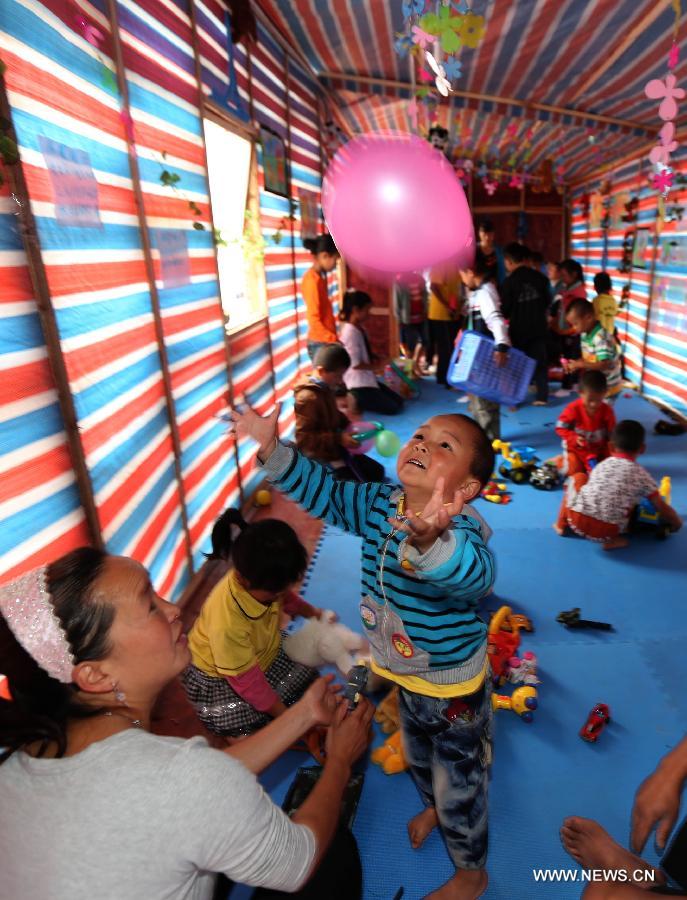 Children play at a children's park in makeshift houses in Longmen Township of Lushan County in Ya'an City, southwest China's Sichuan Province, June 1, 2013. Children in Lushan, which was severely hit by a 7.0-magnitude earthquake on April 20, 2013, spent their children's day here in makeshift houses on Saturday. (Xinhua/Liu Yinghua)