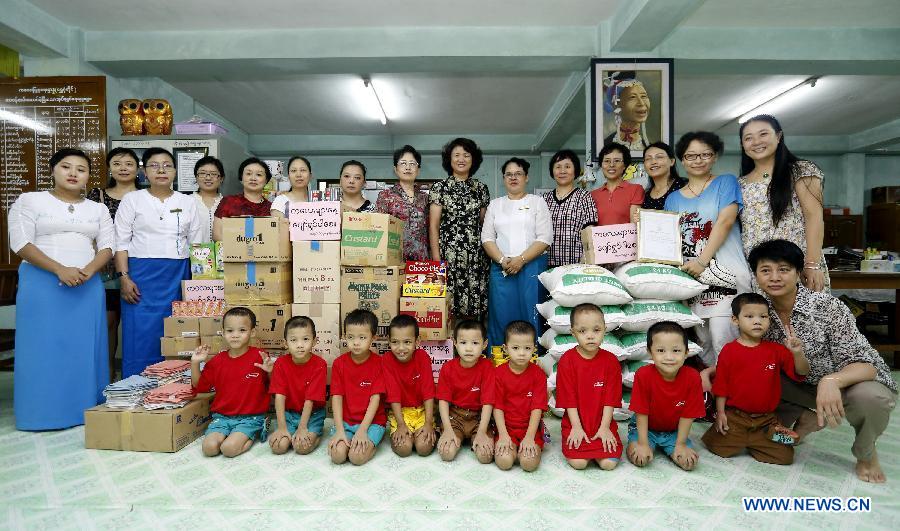 The women team of the Chinese Embassy in Myanmar pose with nursery staff and children at a residential nursery in Yangon, Myanmar, June 1, 2013. A women team of the Chinese Embassy in Myanmar, led by wife of Ambassador Madame Ruan Wei, visited a residential nursery in Shwegondaing, Yangon Saturday, the International Children's Day, for a festive call on children accommodated in the nursery. (Xinhu/U Aung)