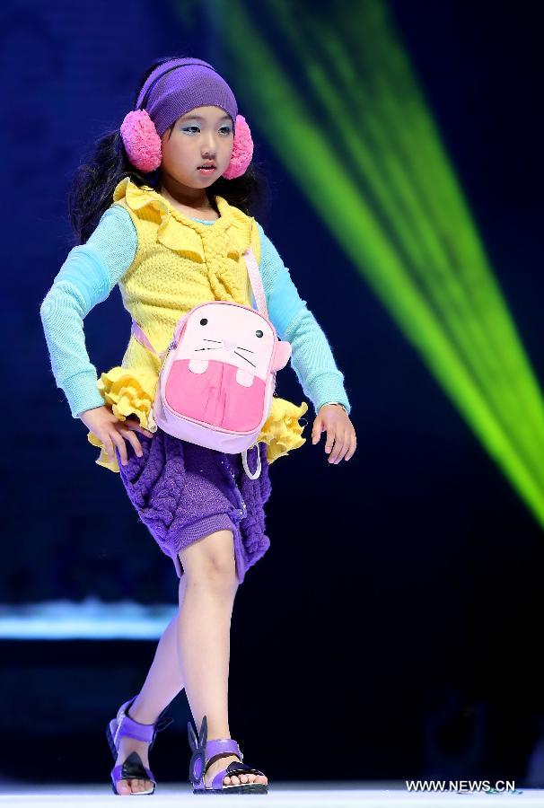 A child presents a creation of children's wear during the final of the first China (Zhili) National Children's Wear Design Contest in Huzhou City, east China's Zhejiang Province, June 1, 2013. Zhili Town, located in the Wuxing District of Huzhou City, is famous for its children's wear. (Xinhua/Chen Jianli)