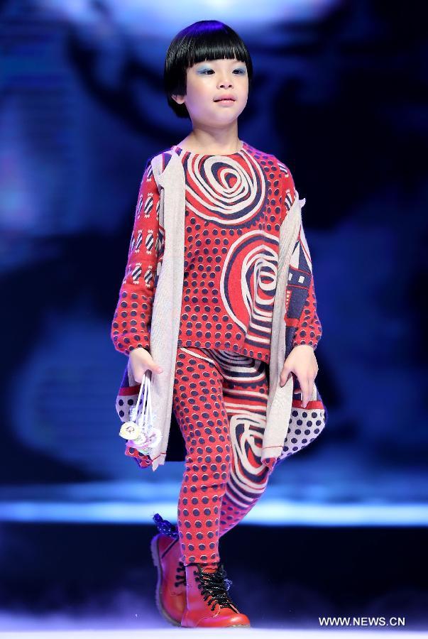 A child presents a creation of children's wear during the final of the first China (Zhili) National Children's Wear Design Contest in Huzhou City, east China's Zhejiang Province, June 1, 2013. Zhili Town, located in the Wuxing District of Huzhou City, is famous for its children's wear. (Xinhua/Chen Jianli)