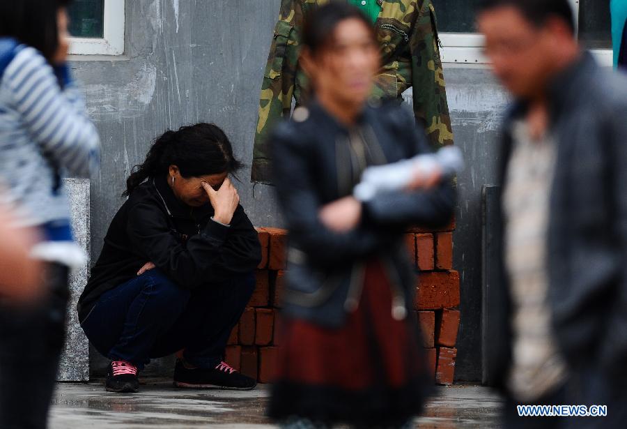 A woman cries as waiting for information after a fire occurred in a slaughterhouse owned by the Jilin Baoyuanfeng Poultry Company in Mishazi Township of Dehui City, northeast China's Jilin Province, June 3, 2013. Death toll from the poultry processing plant fire on Monday morning has risen to 119. Over 300 workers were in the plant when the accident happened. (Xinhua/Xu Chang)