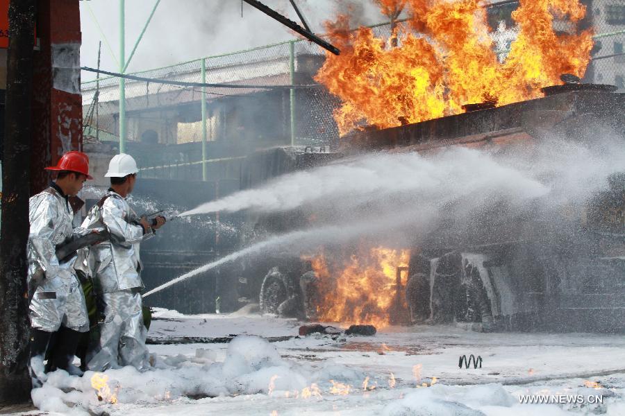 Firemen try to extinguish a fire occurred at a gas station in Hanoi, capital of Vietnam, June 3, 2013. The fire came from a gasoline truck and injured three staff members of the gas station. (Xinhua/VNA)