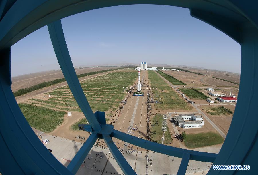 Photo taken on June 3, 2013 shows the assembly of the Shenzhou-10 spacecraft and the Long March-2F carrier rocket at Jiuquan Satellite Launch Center in Jiuquan, northwest China's Gansu Province. The assembly was transported to the launch site on Monday morning, which marks the manned Shenzhou-10 mission entering the final phase of its preparation. The spacecraft, which will be launched in mid-June from the Jiuquan Satellite Launch Center, will carry three astronauts and dock with Tiangong-1, target orbiter and space module. (Xinhua/Liang Jie)