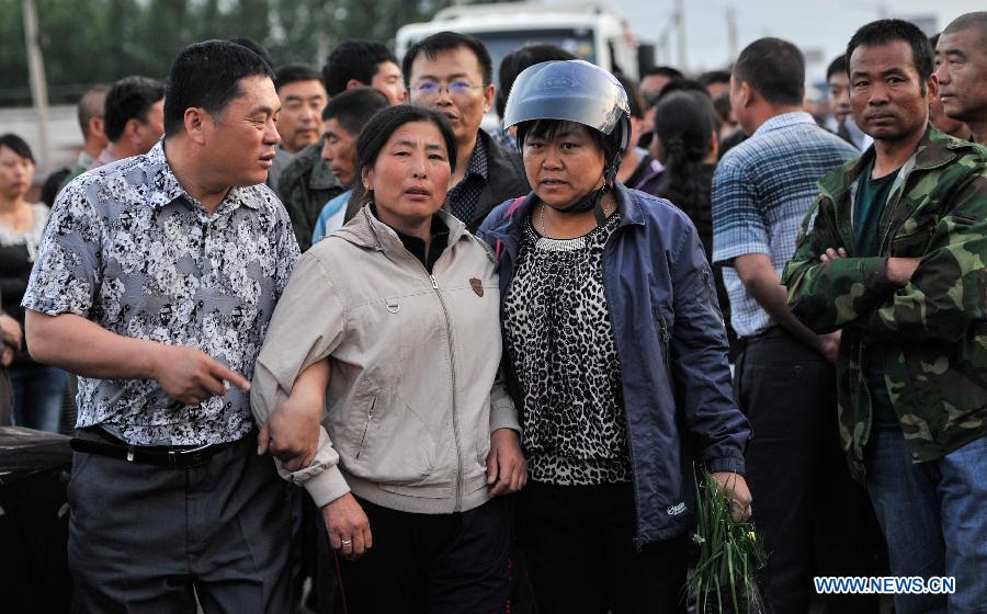 People wait for news of their relatives trapped in a burnt poultry slaughterhouse owned by the Jilin Baoyuanfeng Poultry Company in Mishazi Township of Dehui City in northeast China's Jilin Province, June 6, 2013. The death toll from the fire has risen to 119 as of 8 p.m. on Monday. Search and rescue work is under way. (Xinhua/Wang Hao Fei)