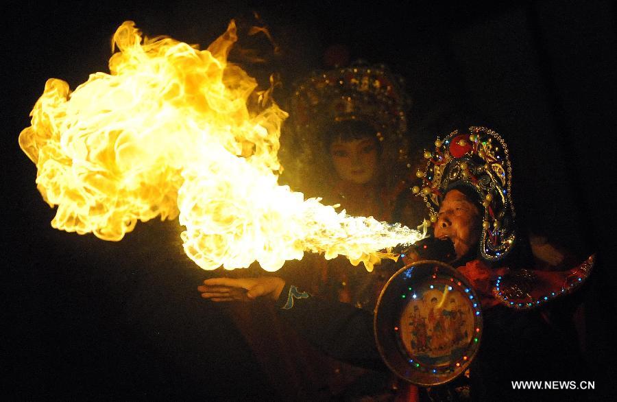 In this file photo taken on Aug. 19, 2012, an actor performs the fire-spitting stunt technique in Sichuan opera at the Wuhou Shrine Museum in Chengdu, capital of southwest China's Sichuan Province. Sichuan opera is one of the oldest forms of Chinese opera, distinguished by face-changing, fire-spitting and other stunts. Regionally Chengdu remains to be the main home of Sichuan opera, while other influential locales include Yunnan, Guizhou and other provinces in southwest China. (Xinhua/Xue Yubin) 