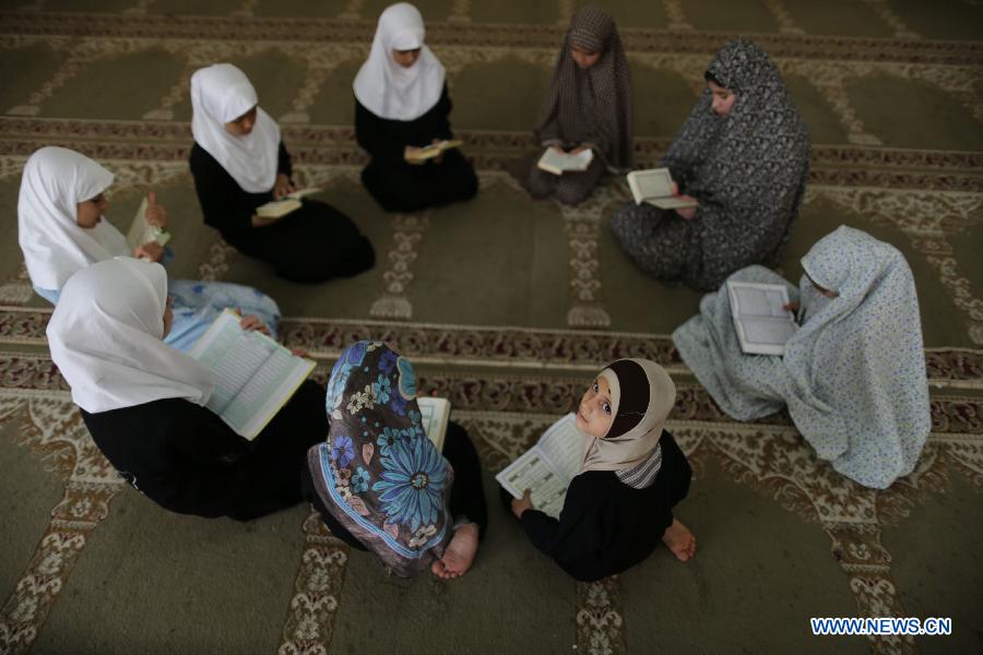 Palestinian girls read Muslim holy book Quran during a lesson at a mosque in Gaza City, on June 3, 2013. (Xinhua/Wissam Nassar) 