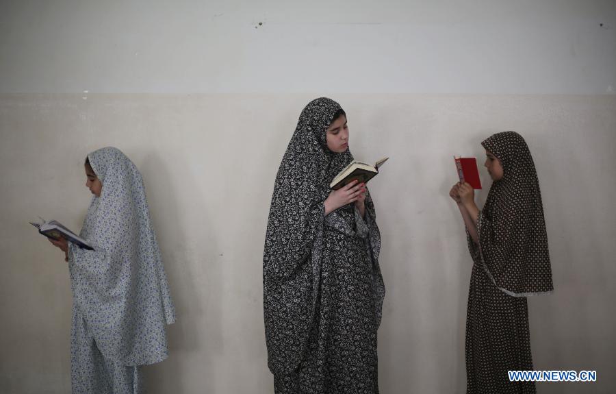 Palestinian girls read Muslim holy book Quran during a lesson at a mosque in Gaza City, on June 3, 2013. (Xinhua/Wissam Nassar) 