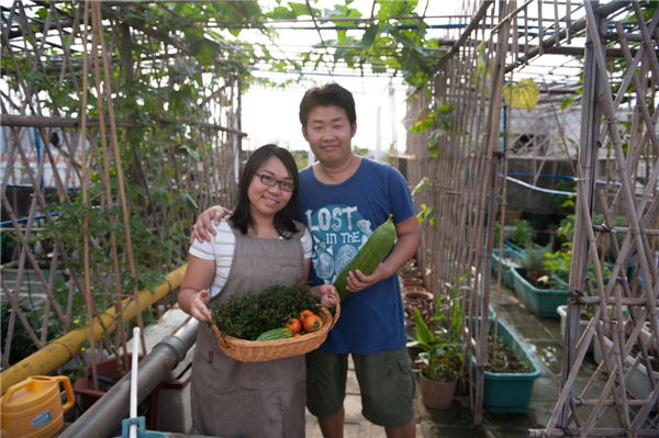 Xian Yuting and her husband Liu Guangmi show their homegrown vegetables at their roof garden in Guangzhou, provincial capital of South China’s Guangdong province, June 2, 2013.[Photo/Xinhua]