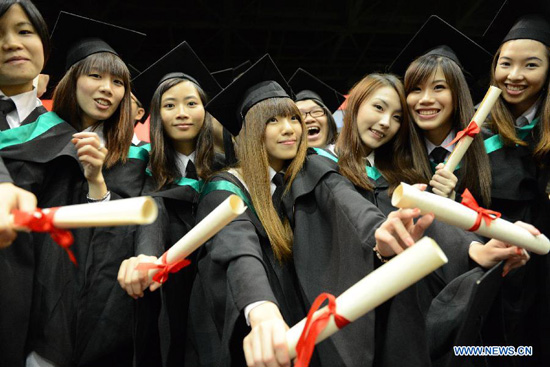 Students pose for a group photo during a graduation ceremony of the University of Macao, south China, June 18, 2012. The university issued graduation certificates for about 1,100 students on Monday. (Xinhua/Cheong Kam Ka) 