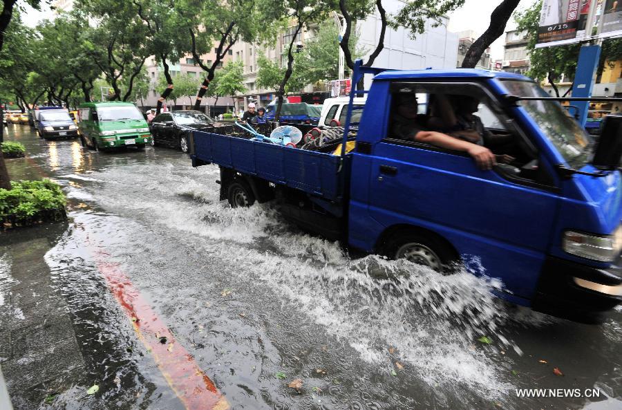 Vehicles move on waterlogged road in Taipei, southeast China's Taiwan, June 4, 2013. A rainstorm and hail hit the city on Tuesday. (Xinhua/Wu Ching-teng)