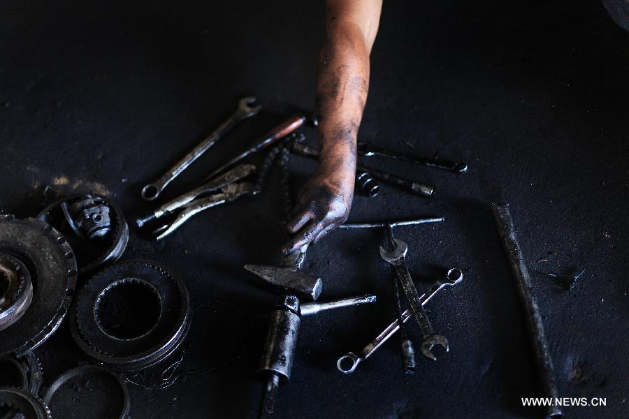 A Palestinian boy works at a garage for repairing cars in Gaza city on June 4, 2013. Many boys left school to work in many different jobs to support their families. Child labor is widespread in the Gaza Strip because of the high rates of poverty. (Xinhua/Yasser Qudih) 